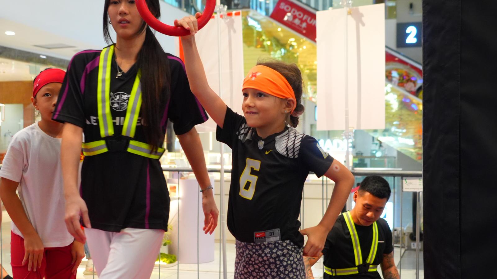 A participant reaching for the next ring, mid-attempt.
