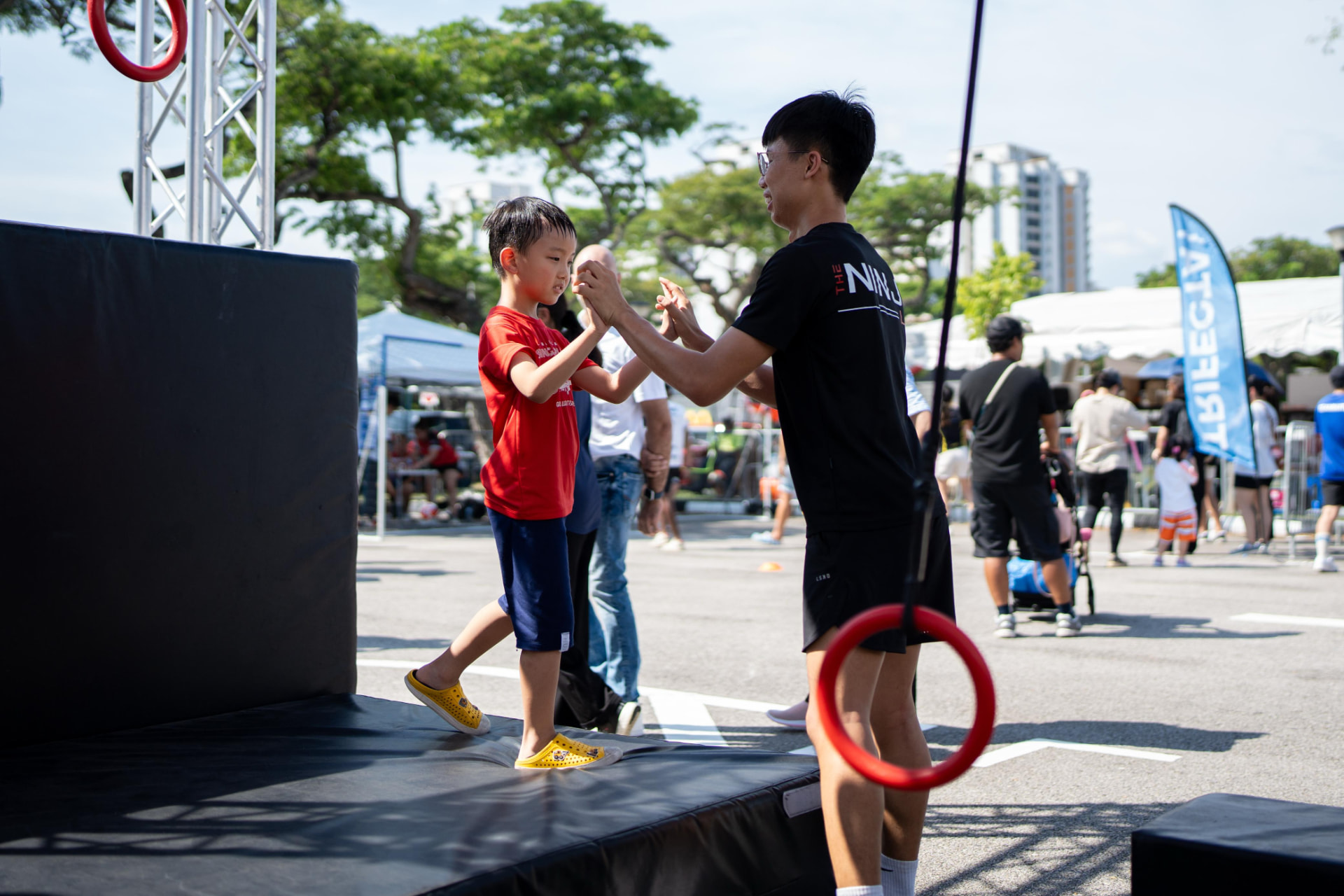 A child high-fiving a coach at the end of an obstacle run.