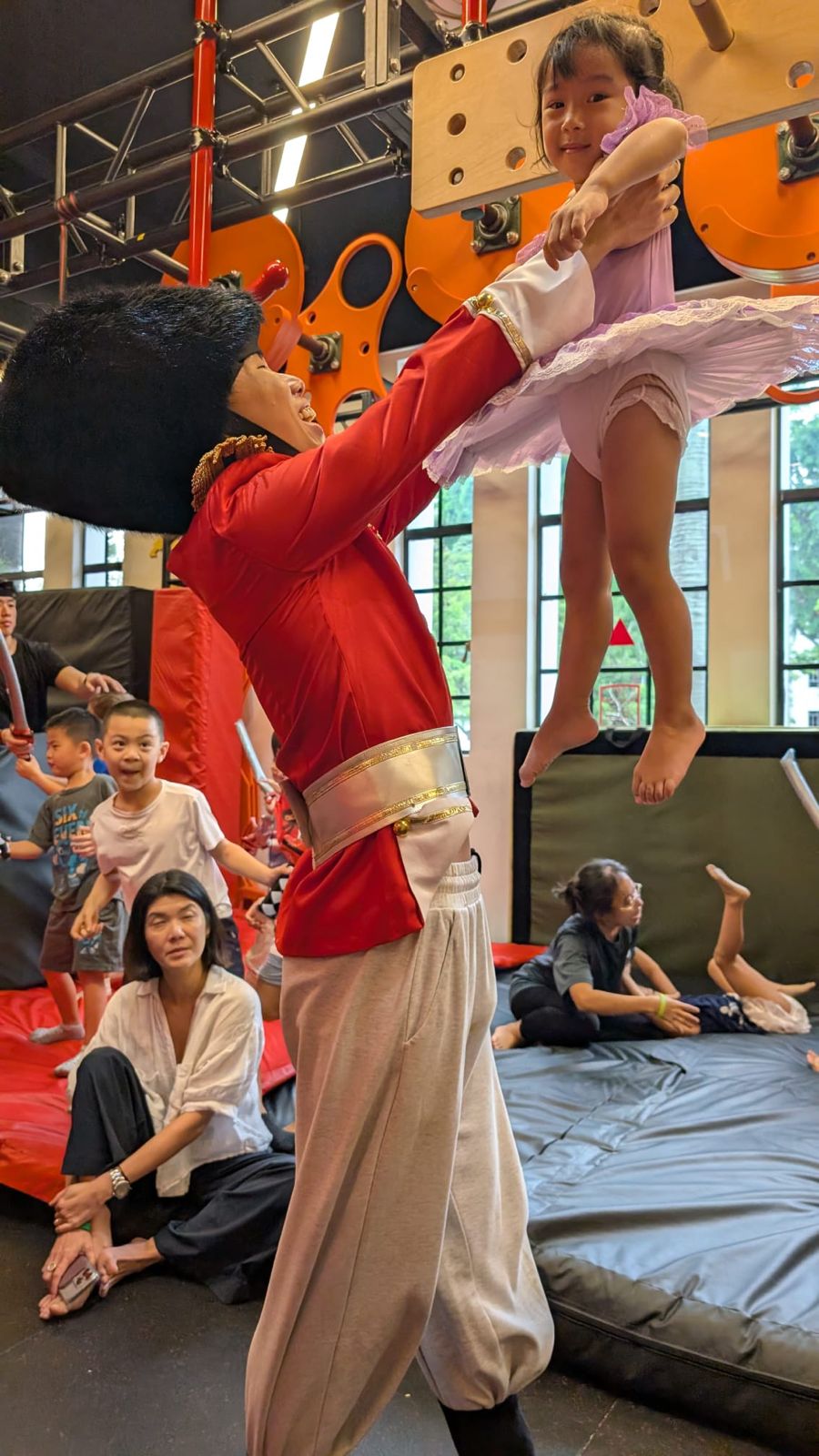 A costumed performer lifting a delighted child at a themed celebration.